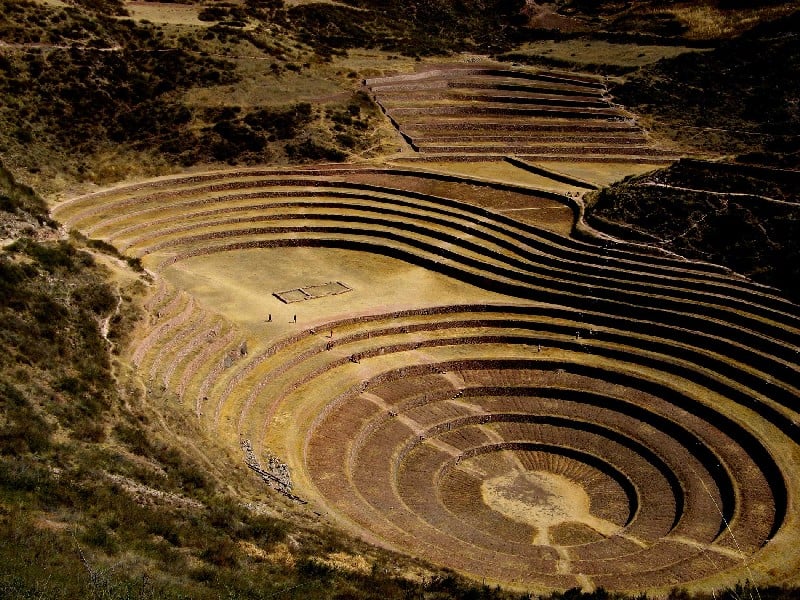 The picture showcases the impressive Moray terraces, a captivating archaeological site near Cusco, Peru. The terraces, arranged in concentric circles, create a mesmerizing sight as they cascade down the natural slopes. Each terrace is meticulously constructed with stone walls and meticulously leveled agricultural beds. The terraces display a range of colors, from earthy browns to vibrant greens, as various crops and vegetation thrive in the fertile soil. The precision and engineering prowess of the Inca civilization are evident in the flawless design of the terraces. The surrounding landscape adds to the allure, with rolling hills and distant mountains providing a stunning backdrop. The picture captures the unique beauty and historical significance of the Moray terraces, inviting viewers to appreciate the ancient agricultural practices and the harmony between human ingenuity and the natural world.