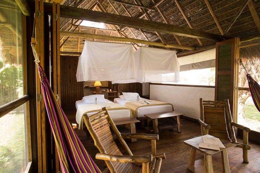 inside of one of Reserva Amazonicas bungalows with beds and hammocks