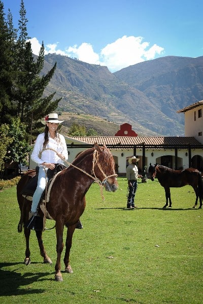 lady on Peruvian Paso horse on the green fields of Hacienda Sarapampa