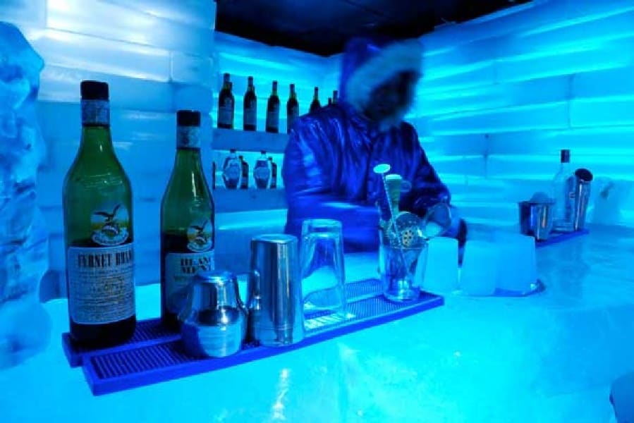 The Glaciobar in El Calafate captivates with its vibrant blue illumination, creating an enchanting atmosphere. The bar counter, made entirely of ice, glistens under the soft lights. A skilled barkeeper stands behind the counter, ready to serve guests with refreshing drinks, adding to the unique experience of this icy wonderland.