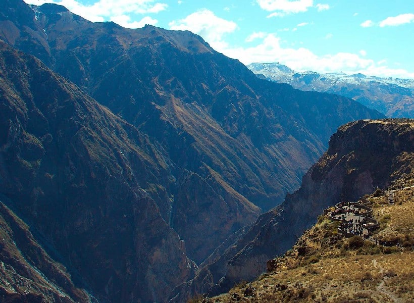 Scenic overview over the Colca Canyon from the Cruy del Condor. Blue sky and green mountains.