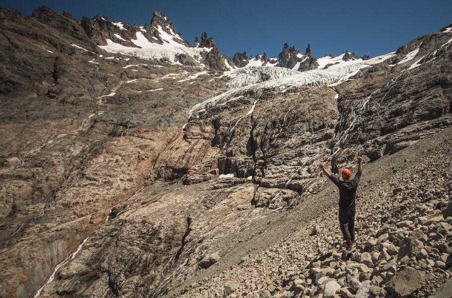 Tourist climbing the Penon Glacier over a stone field, Carretera Austral.
