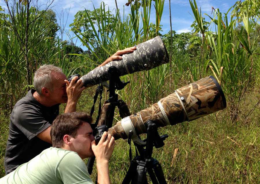 Two photographers with big teles at the Macay Clay Lick in Tampopata
