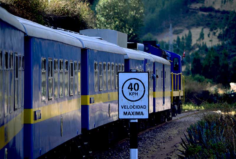 Blue Andean Explorer train passing by a sign displaying the maximum speed of 40 kilometer per hour