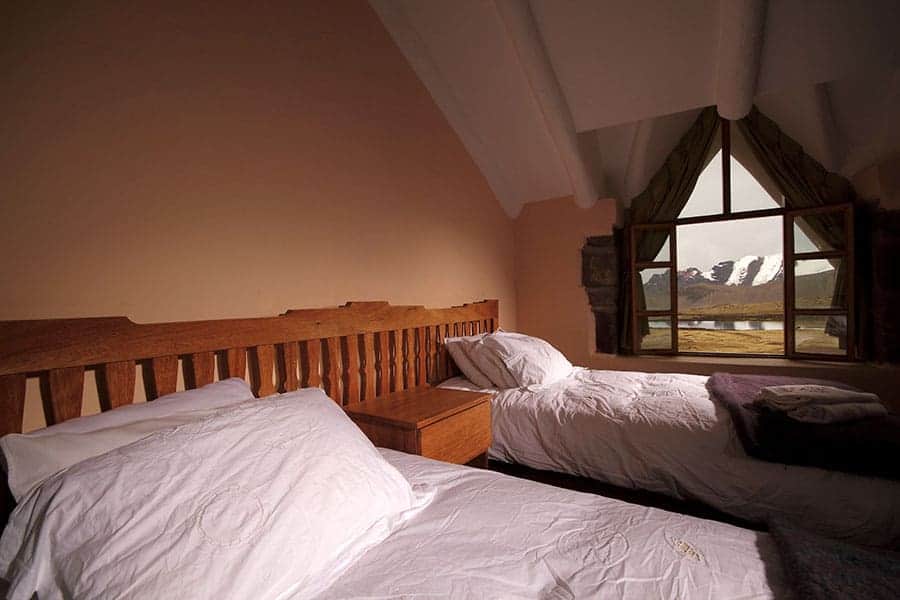 Room at Huampococha Lodge with window overlooking Ausangate Mountain range