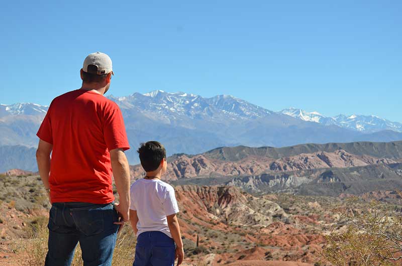 Salta Argentina - Father and son watching the Cachi snow-capped mountain range