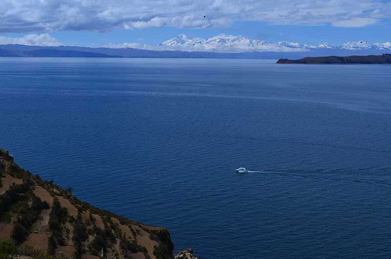 The intense blue of Lake Titicaca and the snowcapped Royal Mountain Range on the Bolivian side as background