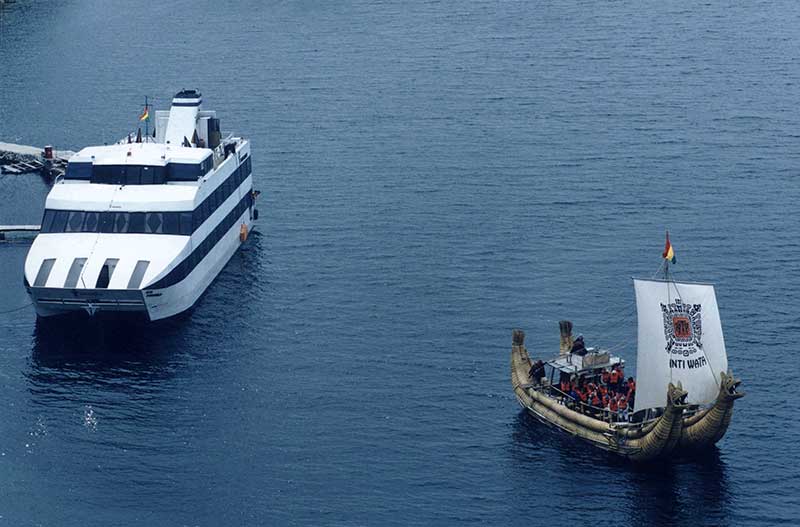 Catamaran on the blue Lake Titicaca and besides a reed sailing boat