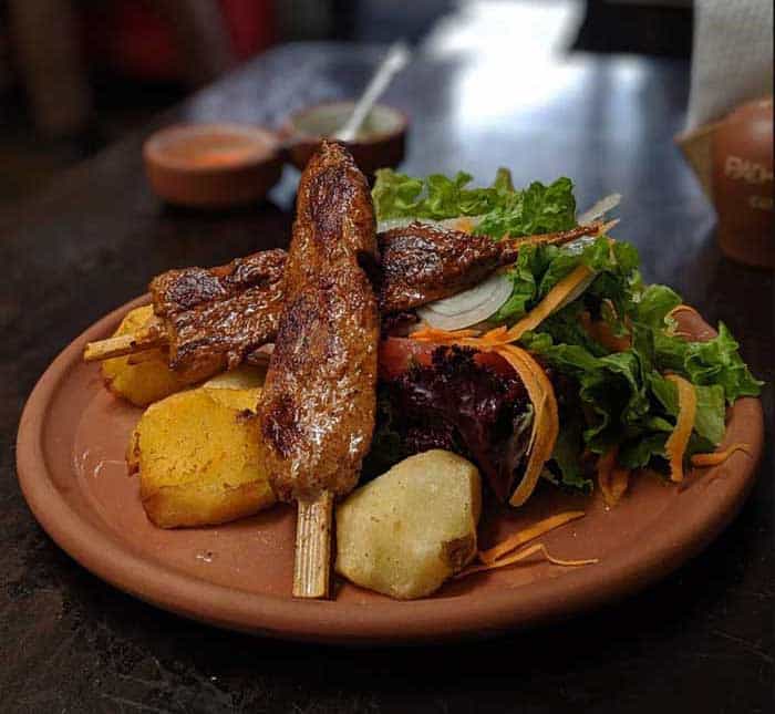 Alpaca skewers served with potatoes and salad