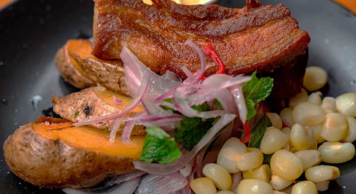 What to Eat in Cusco - Cusquenan-style fried pork belly served with maize, potatoes and onion salad