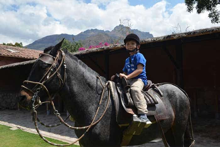 Six-year old boy doing horseback riding in the Sacred Valley of Cusco