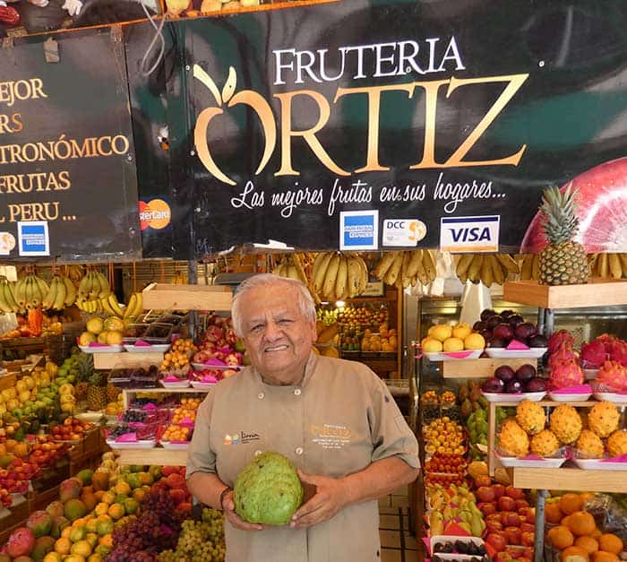 Mr Ortiz and his fruit stand in San Isidro's market - Lima, Peru