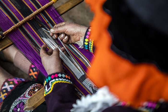 Female hands weaving with a waist loom in the Potato Park, Cusco