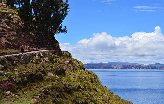 Lake Titicaca and Puno - lady walking along a path with Andean views on Taquile Island
