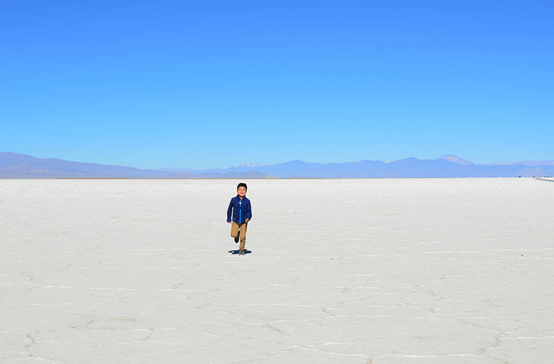 Kid running on Salinas salt flats in Northern Argentina 