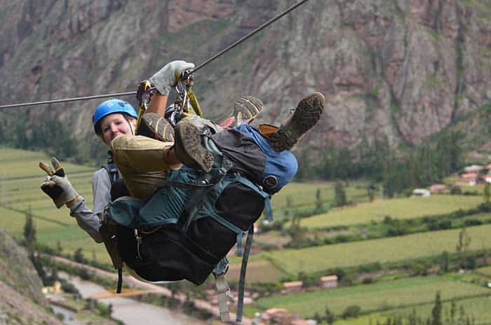 A tourist ziplining down with a guide from Skylodge Peru to the Sacred Valley 