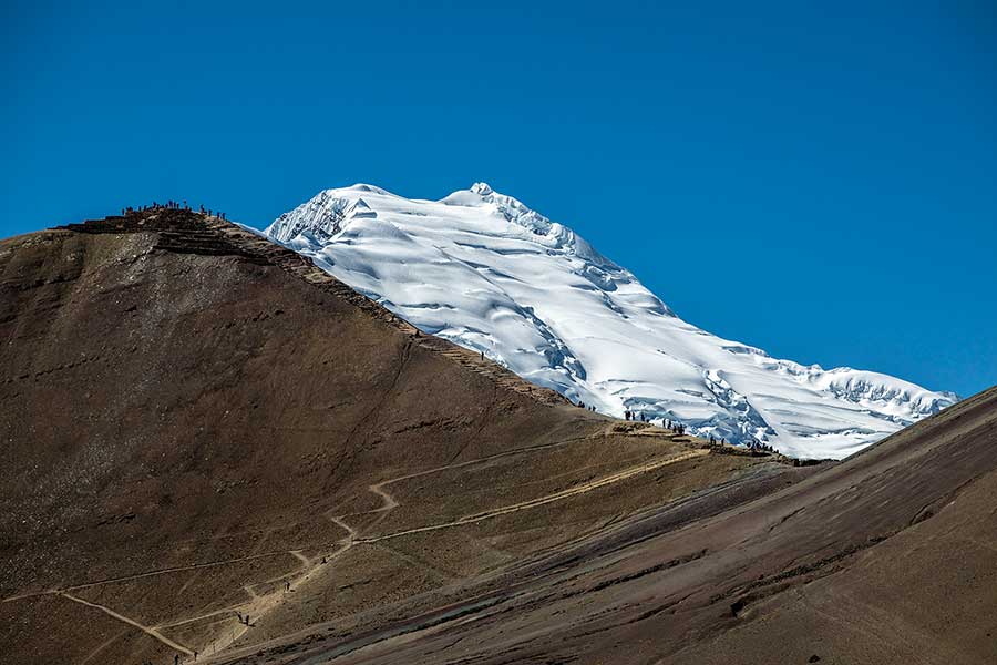 Travelers along the path to the lookout point in the Red Valley (from Vinicunca Rainbow Mountain)