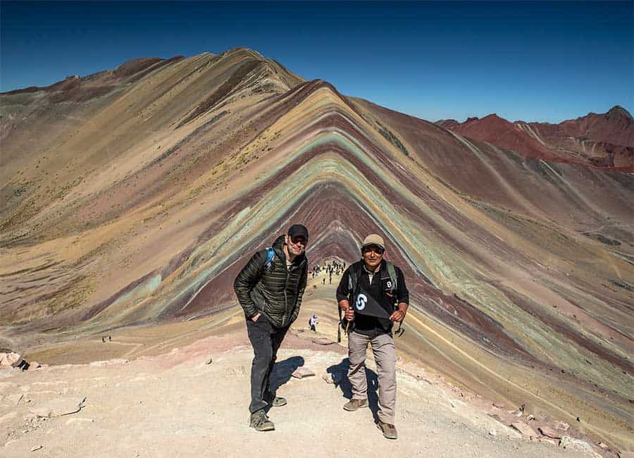 Two men reaching the outlook point of Vinicunca Rainbow Mountain 
