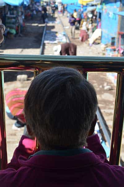 man in front of view of market from titicaca train in Puno