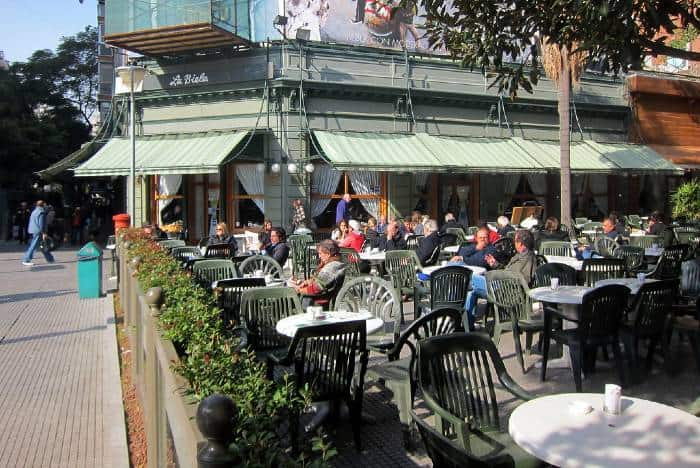 People sitting at the outdoor tables at the traditional La Biela, Buenos Aires on a sunny day 