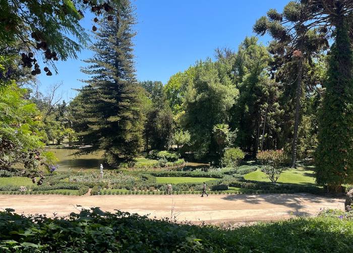 A person walking in the green outdoors at Casa Real hotel within Santa Rita winery near Santiago de Chile