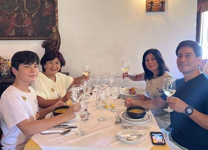 A family of four raising wine glasses at a table in Dona Paula's restaurant 