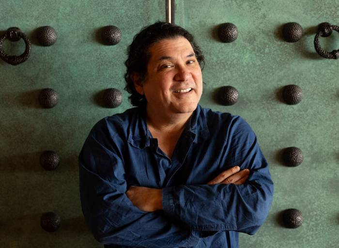 the prominent Peruvian chef Gaston Acurio posing for the camera and smiling with a green colonial door in the background