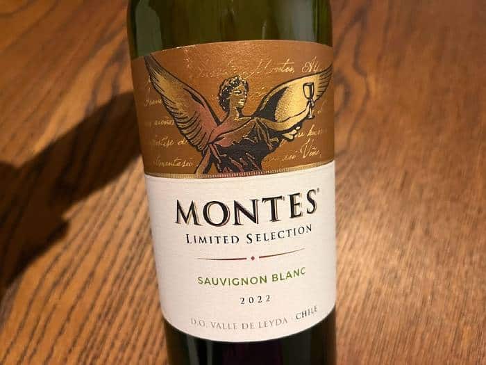 A green bottle of Montes Sauvignon blanc wine. The label features a gold angel raising a glass  