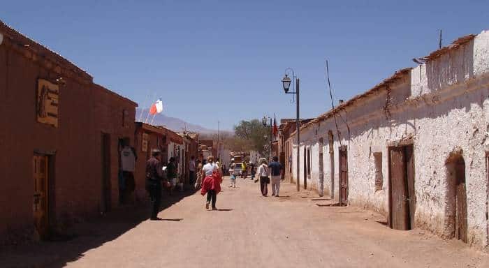 Tourists walking along the Caracoles Street in San Pedro de Atacama's main street (one-storey shops built with mud bricks)