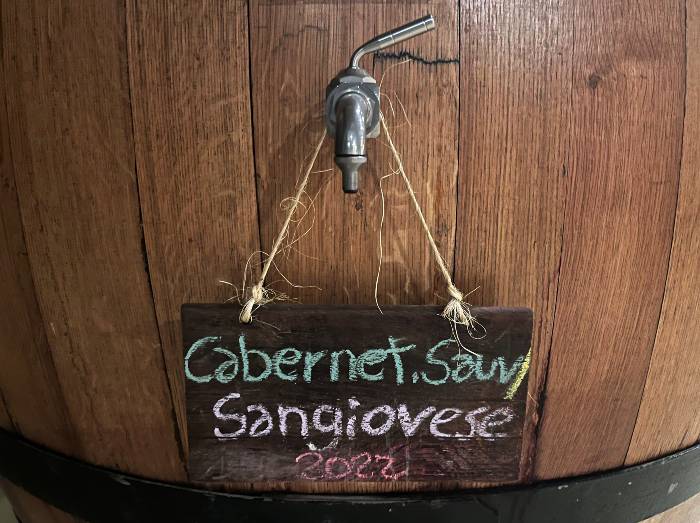 Barrel with a sign featuring the wine sort Cabernet Sauvignon and Sangiovese 2022