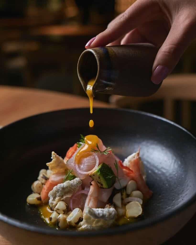 pouring lime mixture over civiche osaka restaurant lima