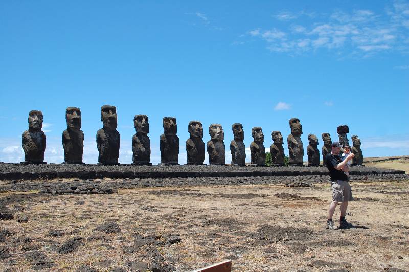 15 moais standing at Ahu Tongariki with man carrying child in arms