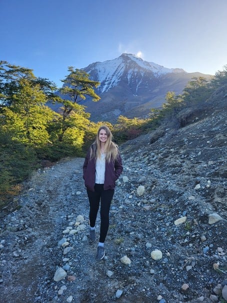 Amy hiking along a rocky trail on a clear day on the way to Las Torres (Paine Towers)