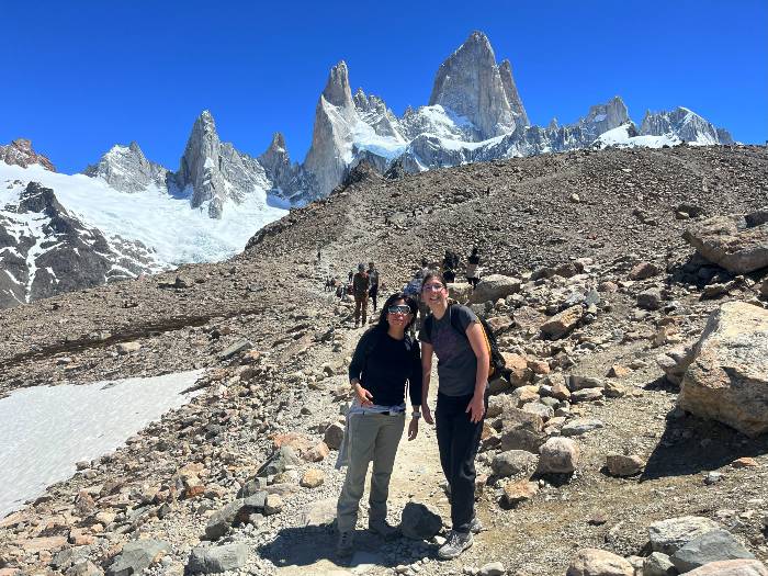 2 ladies smiling with Fitz Roy snowcapped mountains as backdrop in El Chalten Argentina
