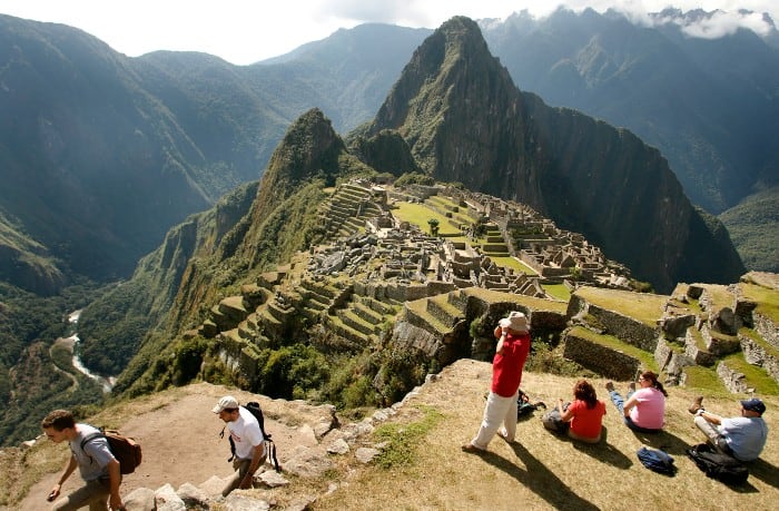 Tourists close admiring Machu Picchu citadel and the surrrounding mountain from a spot close to the Guard House